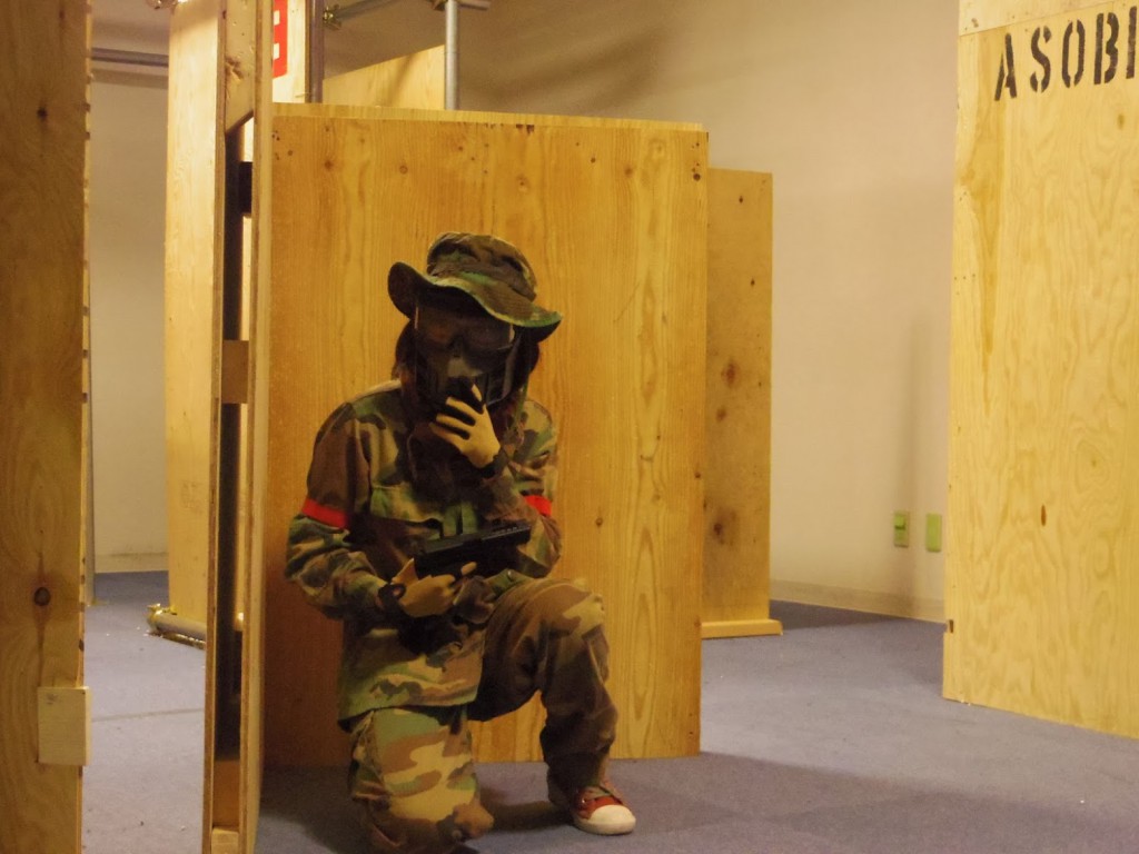 バリケードに隠れる女性サバゲーマー